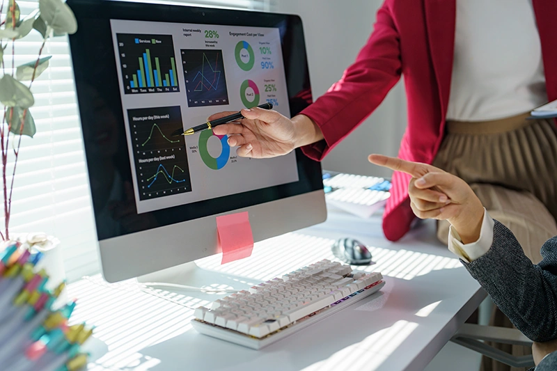 Deux professionnelles analysent des indicateurs financiers et graphiques sur un &eacute;cran pour orienter la strat&eacute;gie de leur entreprise