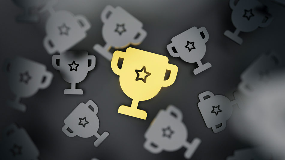 Troph&eacute;e dor&eacute; brillant parmi d'autres troph&eacute;es gris, symbolisant la reconnaissance, les r&eacute;compenses et le partage de la valeur dans le cadre des nouveaut&eacute;s en mati&egrave;re de primes pour les employ&eacute;s.