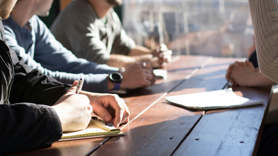 Ordinateur portable &agrave; moiti&eacute; ferm&eacute; sur un bureau en bois, &eacute;voquant l'absence de travail ou une pause li&eacute;e &agrave; un cong&eacute; ou un arr&ecirc;t de travail.
